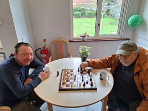 Two men sat at a table playing chess